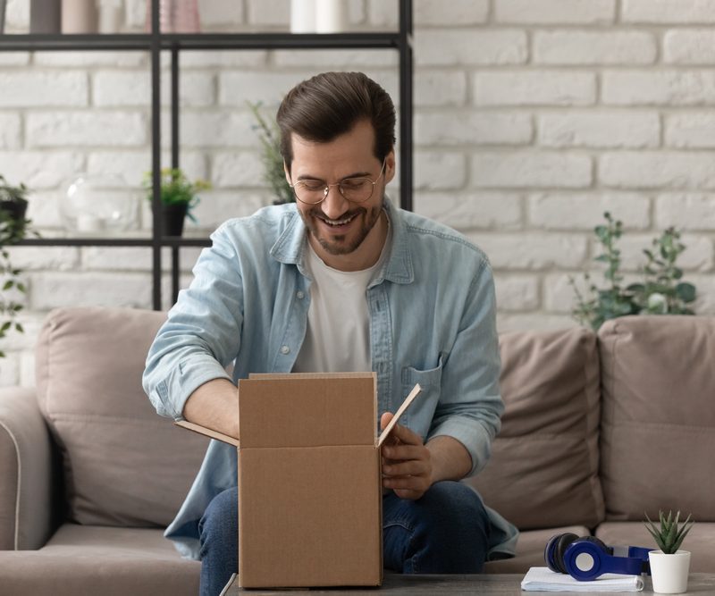 Unpacking,Parcel.,Happy,Young,Man,Postal,Delivery,Service,Client,Sit